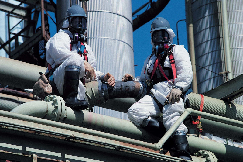 Image of two people removing asbestos from a building