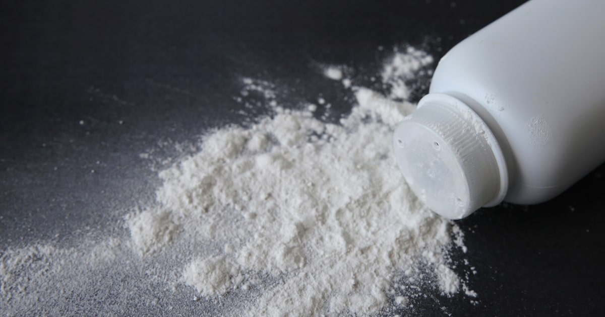 A white bottle spilling talcum powder on black background.